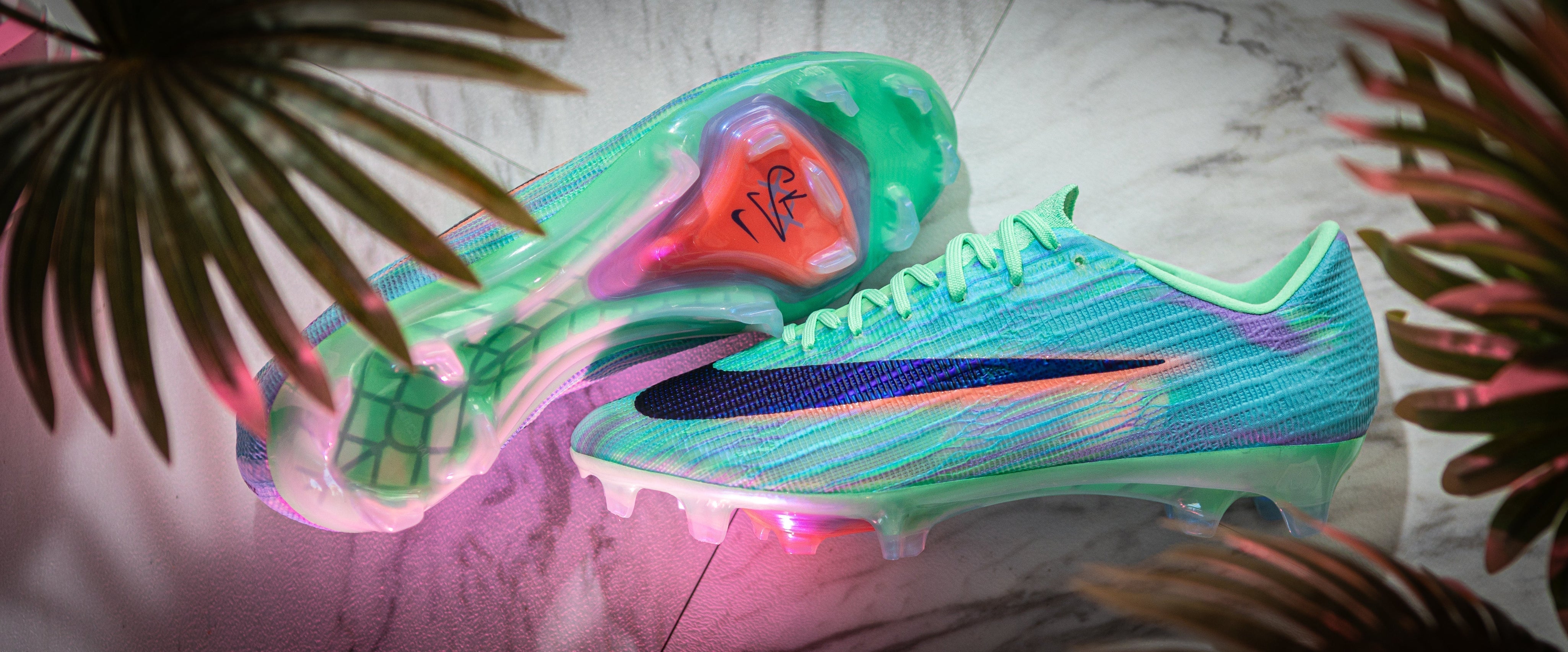 Side profile and soleplate of the Nike Mercurial Sam Kerr Special Edition football boot on marble with palm leaves