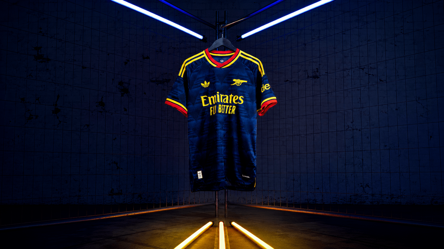 27 Away Jersey in navy and yellow hanging under blue lights