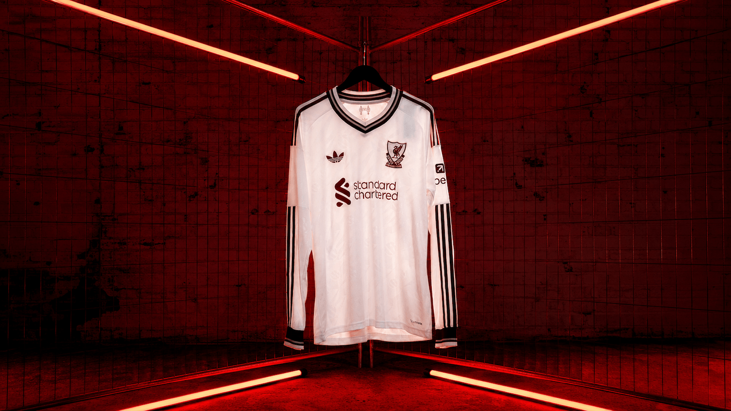 27 Away Jersey in white with deep red details, displayed under red lights