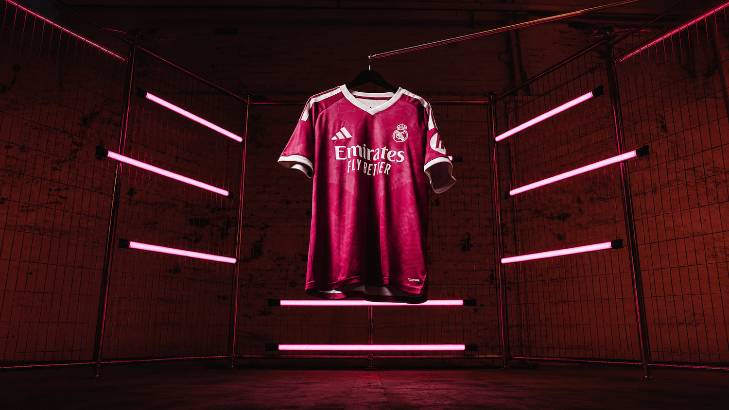 27 Third Jersey in rich pink with off-white details, suspended among pink neon lights.