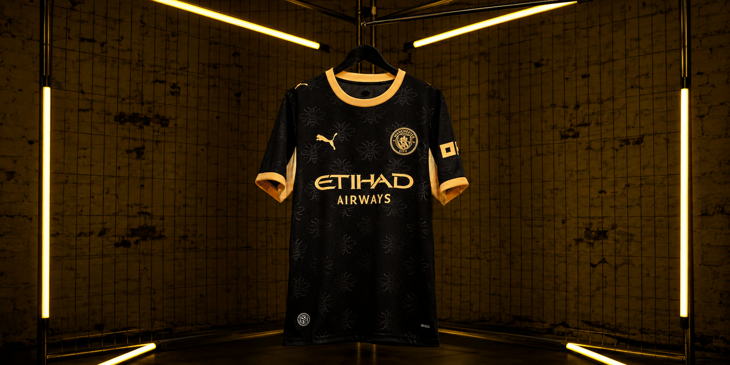 27 Away Jersey in black with gold details and worker bee pattern